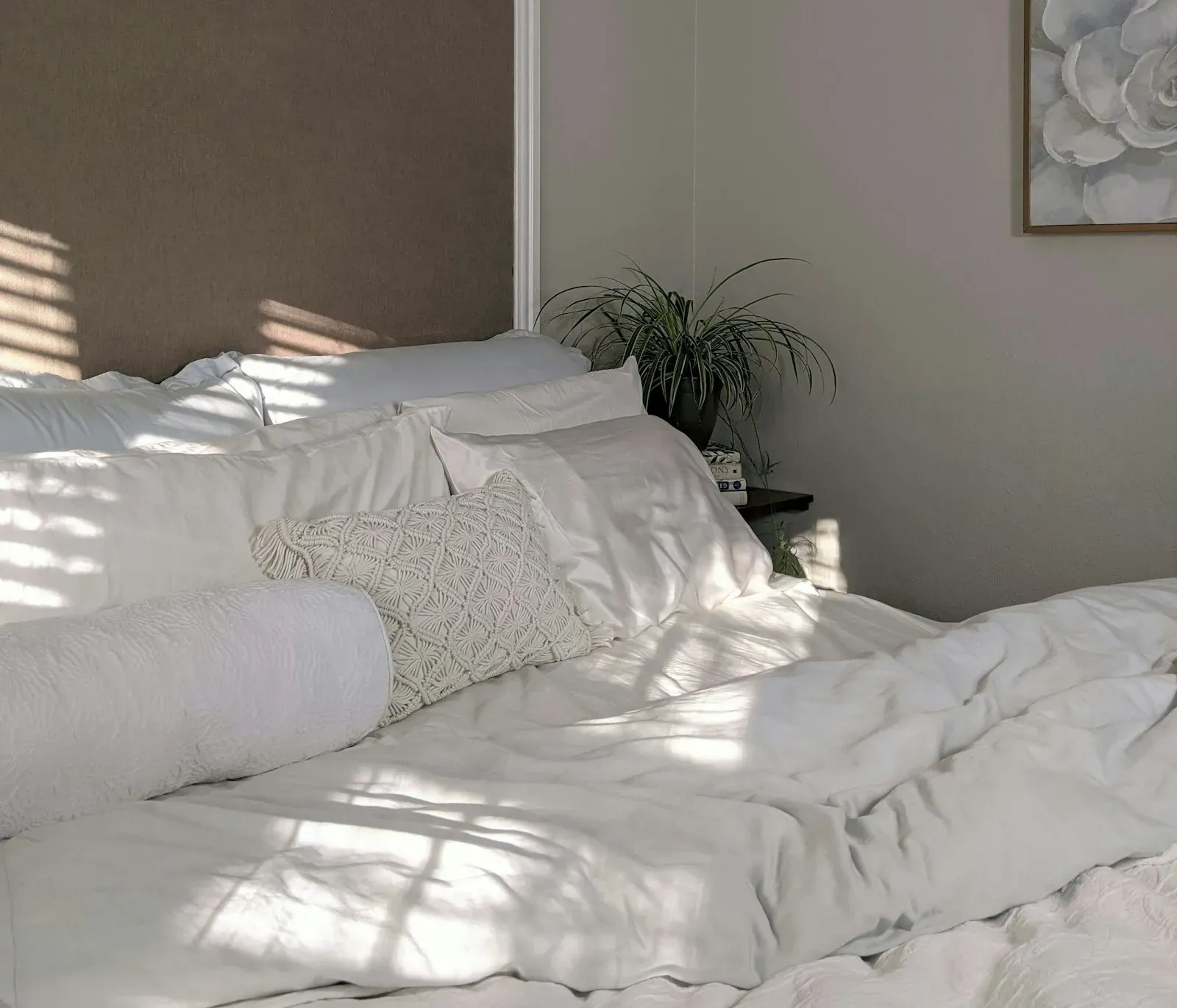 Made bed with crisp white bedding and natural light in a calm bedroom